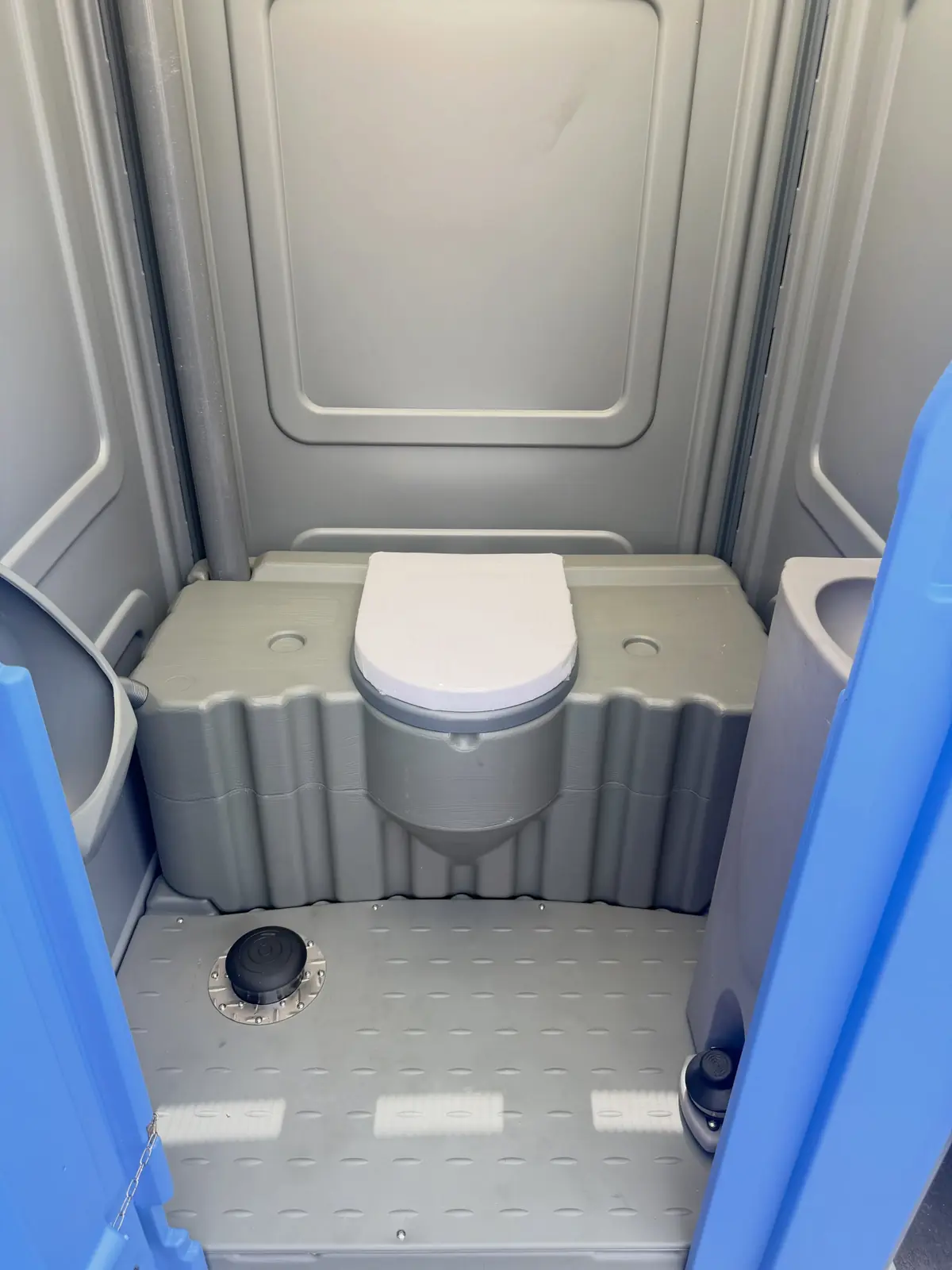 Clean porta potty interior with the seat closed after a service visit
